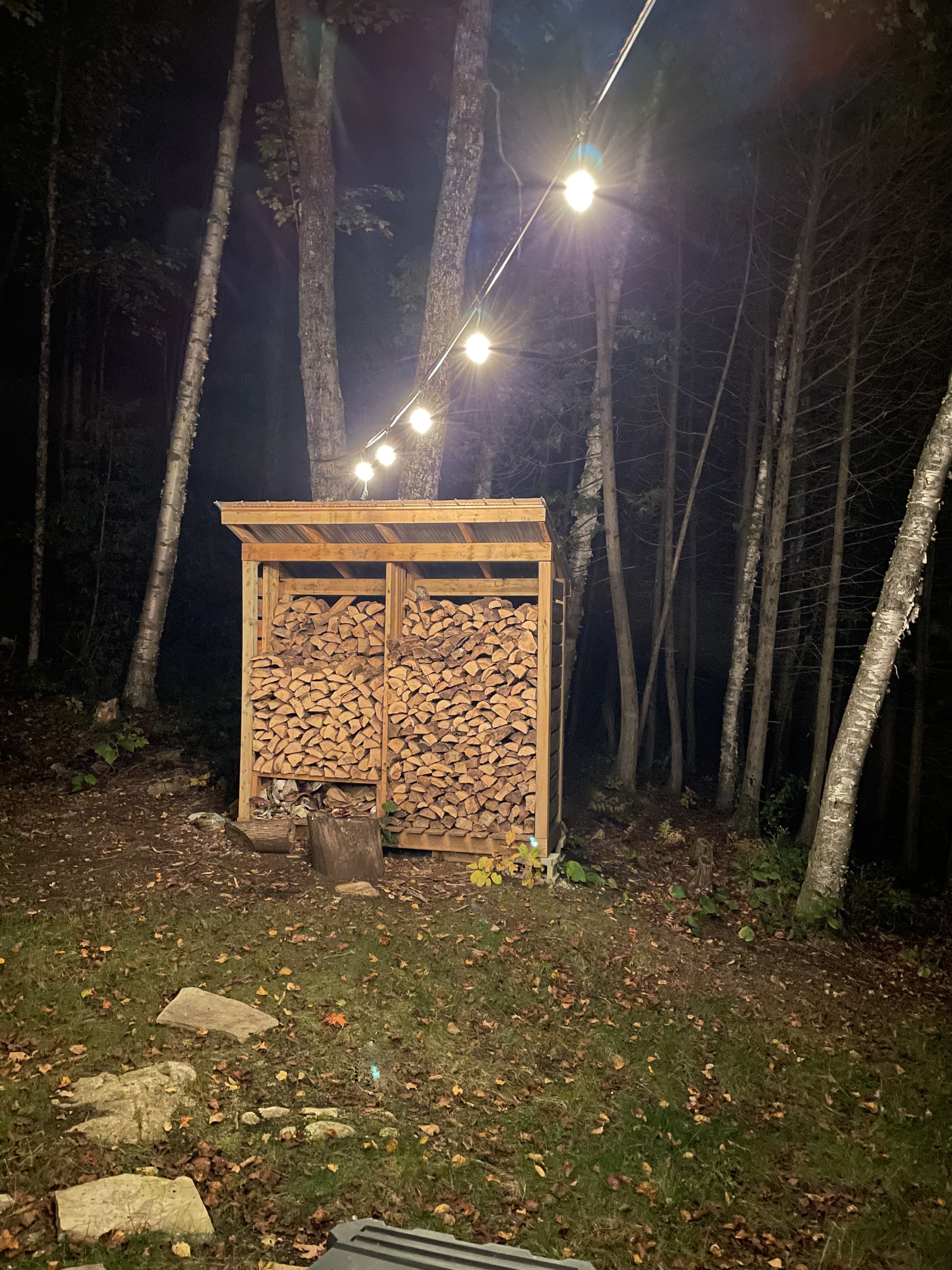 The completed shed at night. It now includes a “compartment” at the front bottom left for kindling.