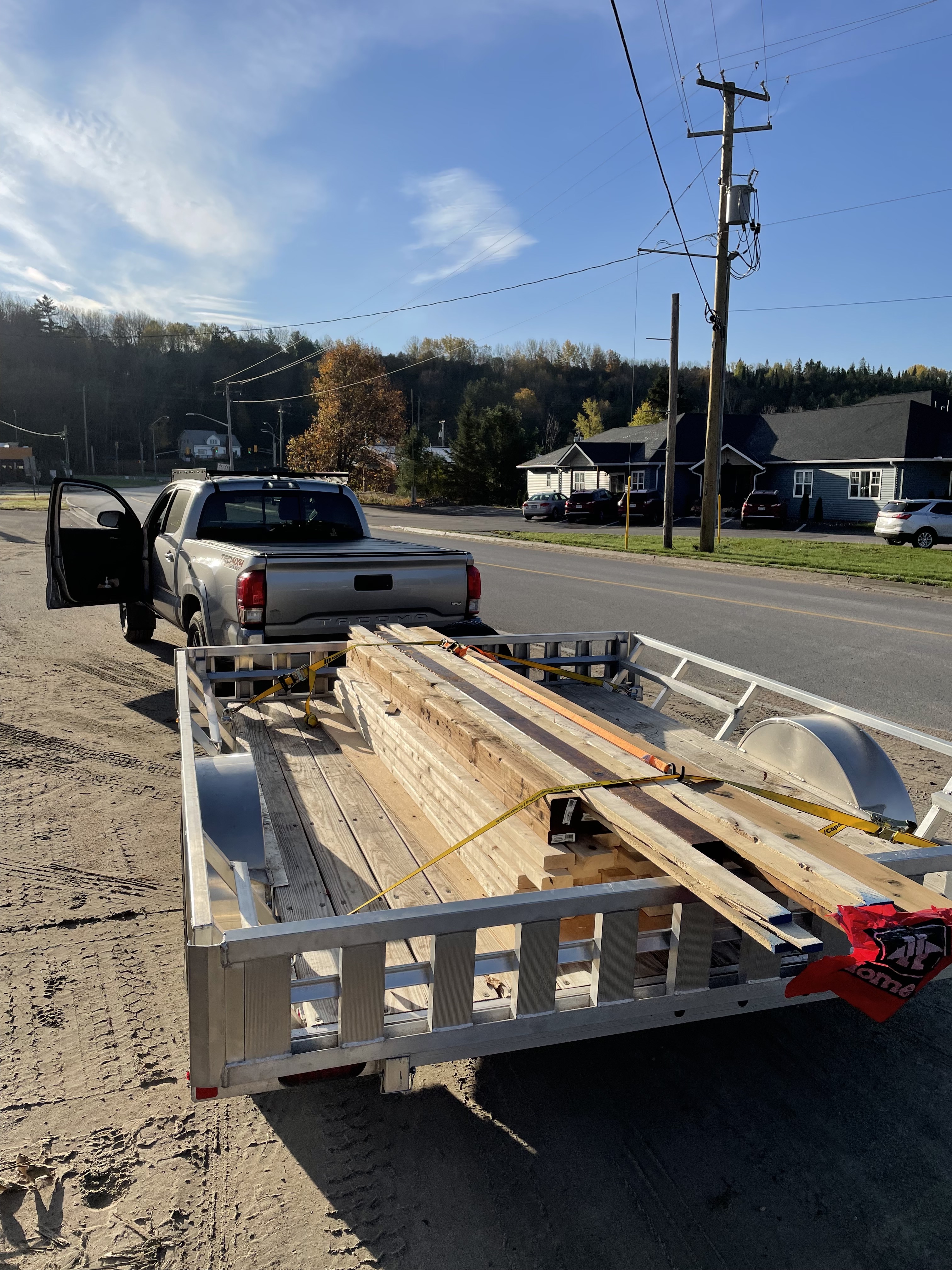 The ten foot long aluminum trailer with an array of longer boards on it, and a red flag stapled to the end