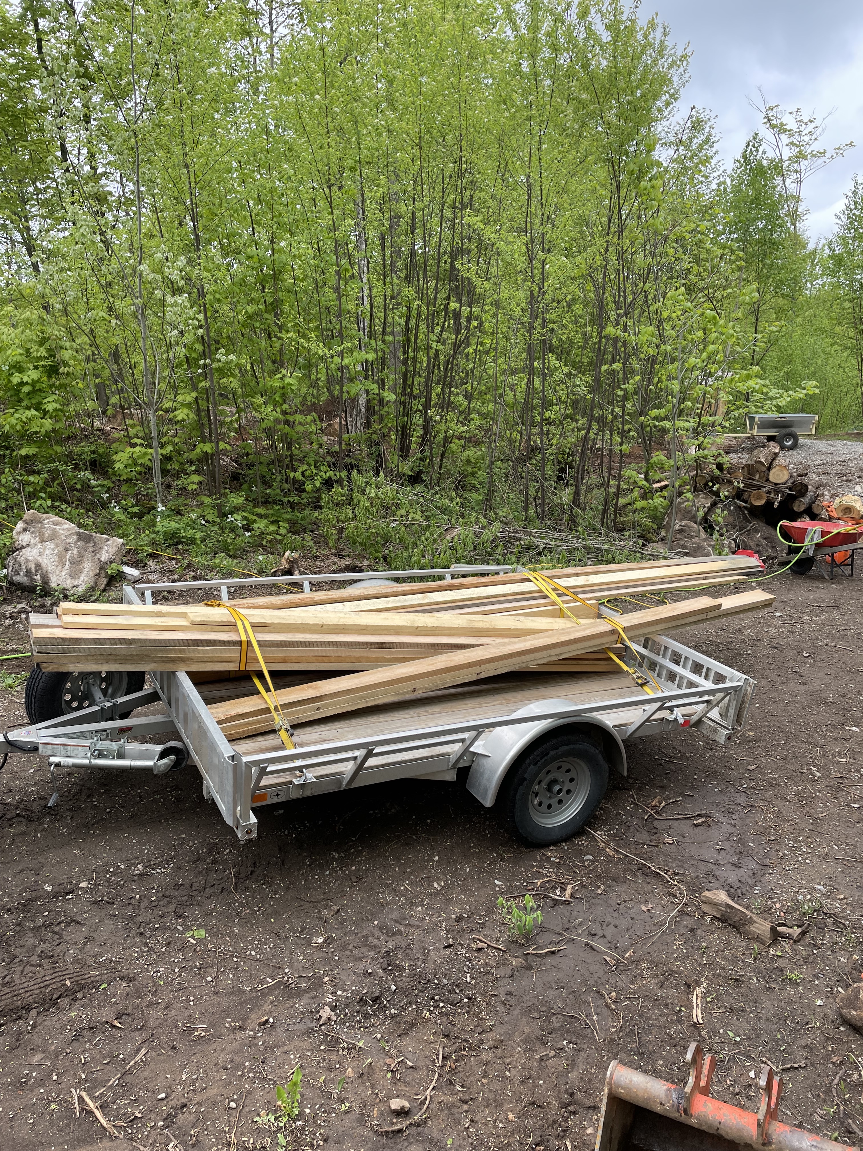 The ten foot long aluminum trailer with an array of 12-14 foot boards strapped to it