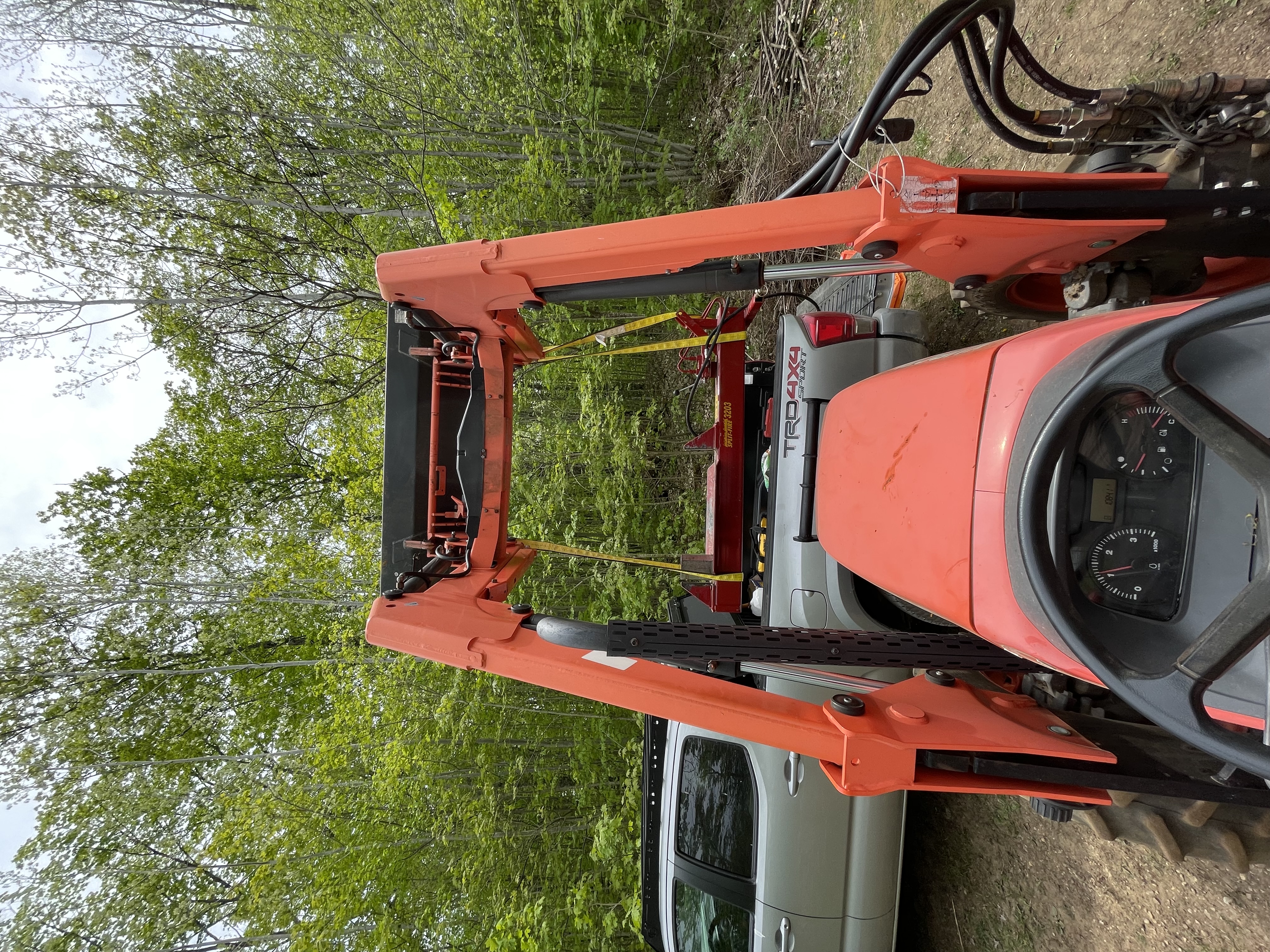 Unloading the splitter from the pickup bed with the tractor loader