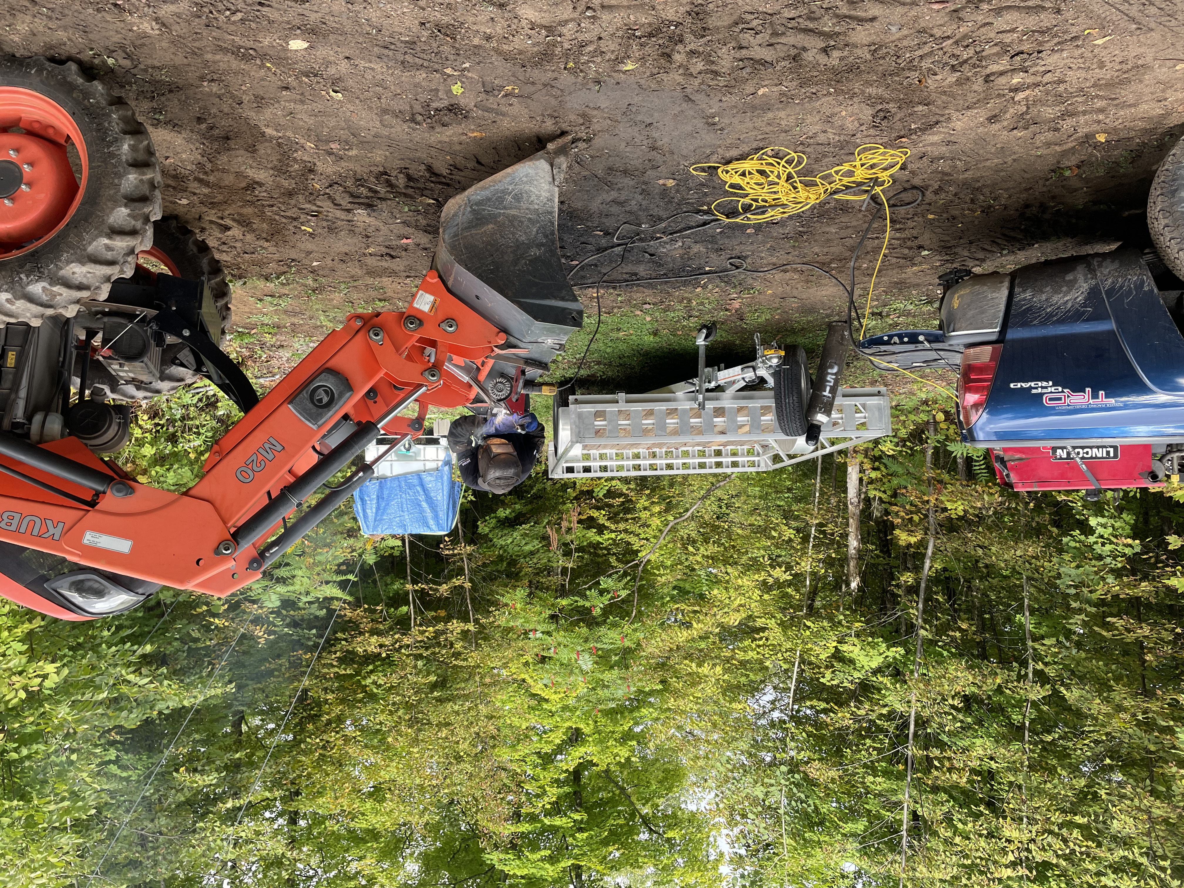 A welder working on the bucket of the tractor