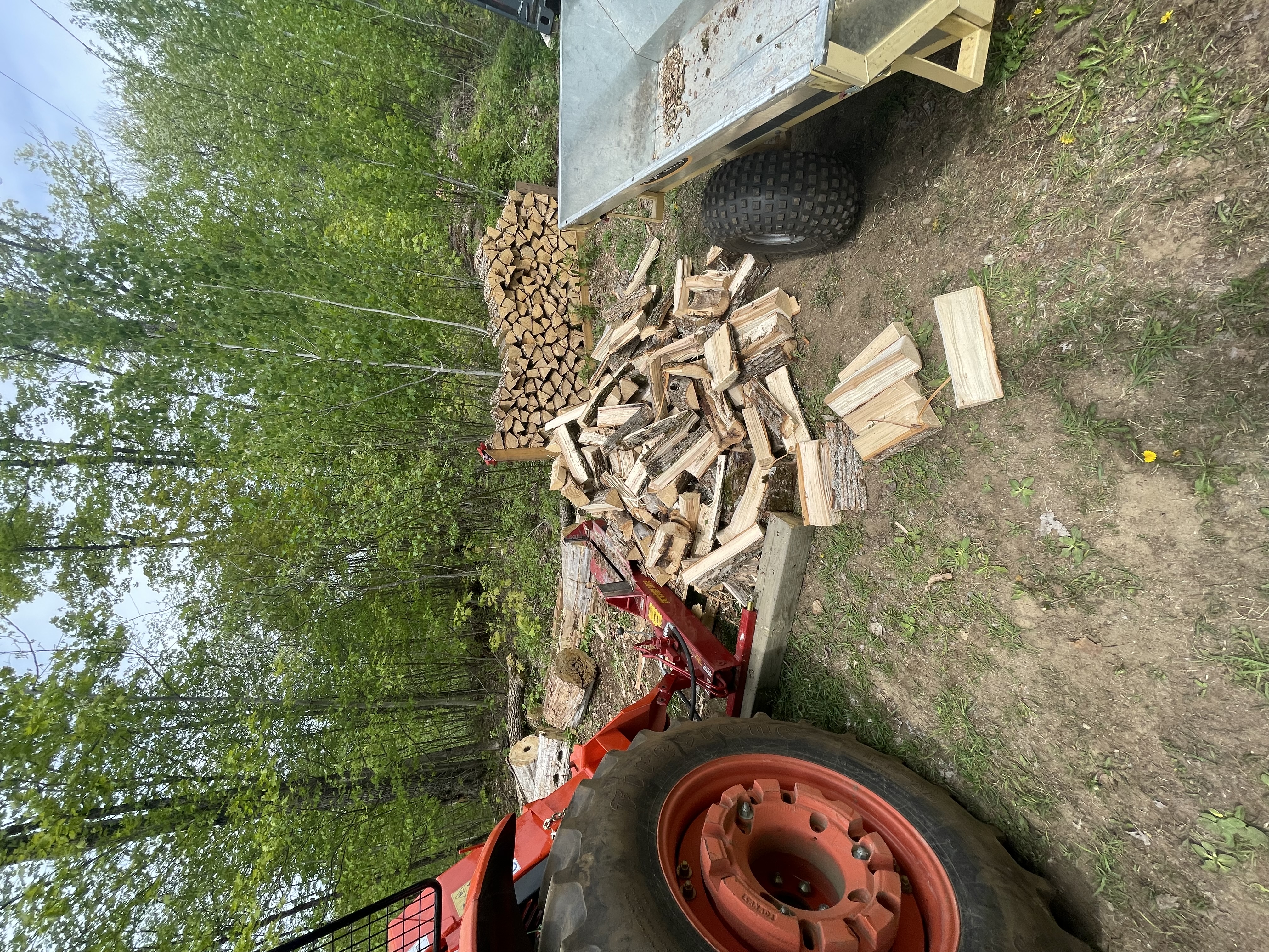 The splitfire behind the tractor, but not attached to the 3-point hitch. Instead, it sits behind the winch, hydraulic lines running behind and up to the hydraulic ports.