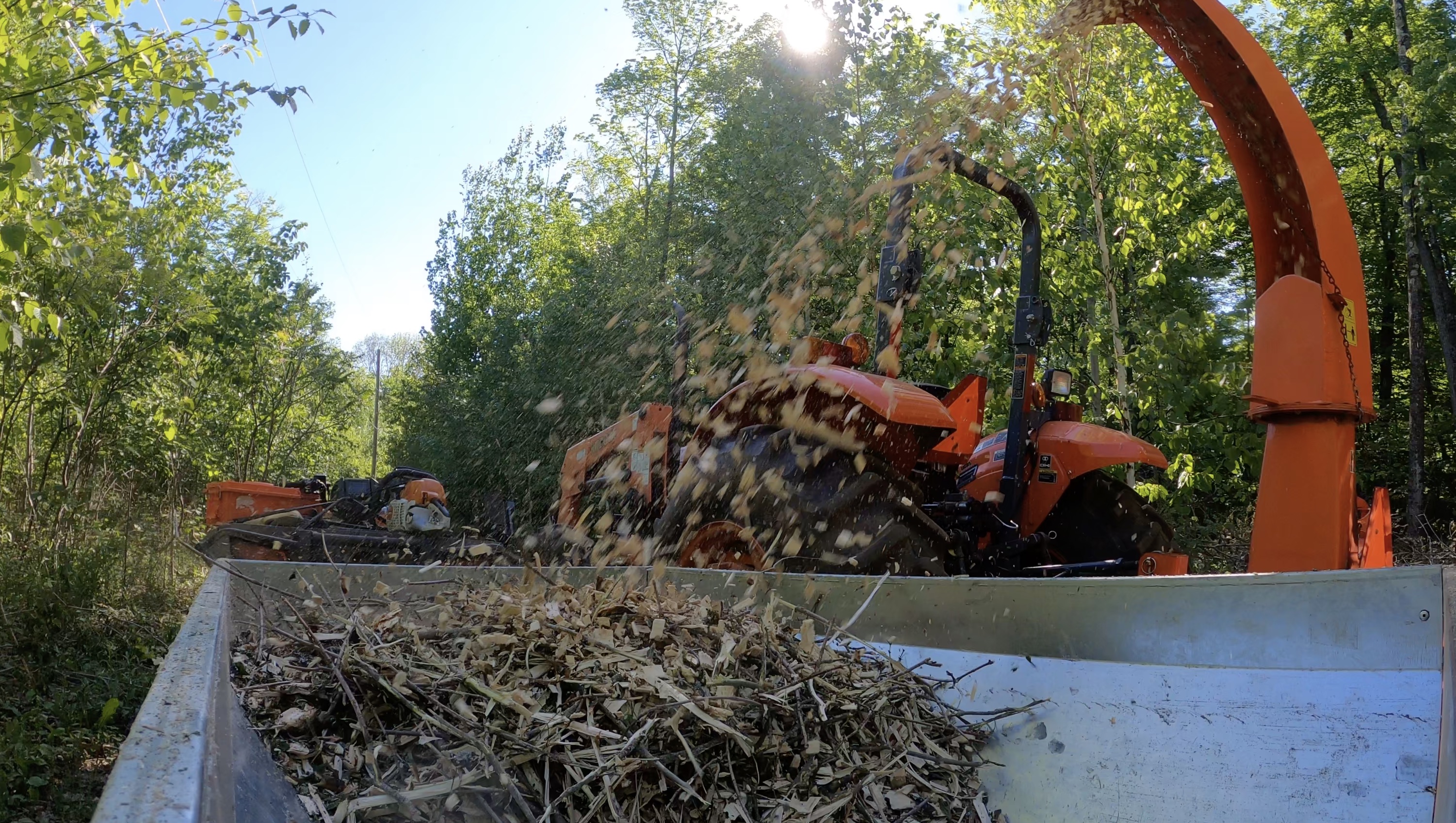 A thumbnail for a video montage of using the wood chipper and spreading the chips as ground cover