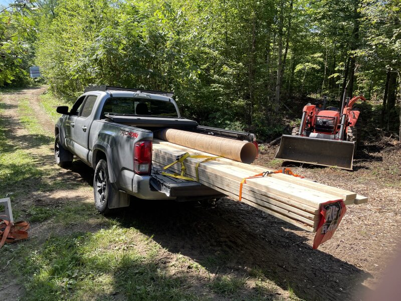 The Tacoma, tailgate down, full of lumber and sonotubes