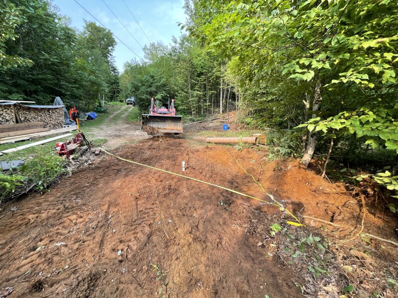The reverse view of the tractor from the back of the build site, tape measures laid out indicating the approximate footprint