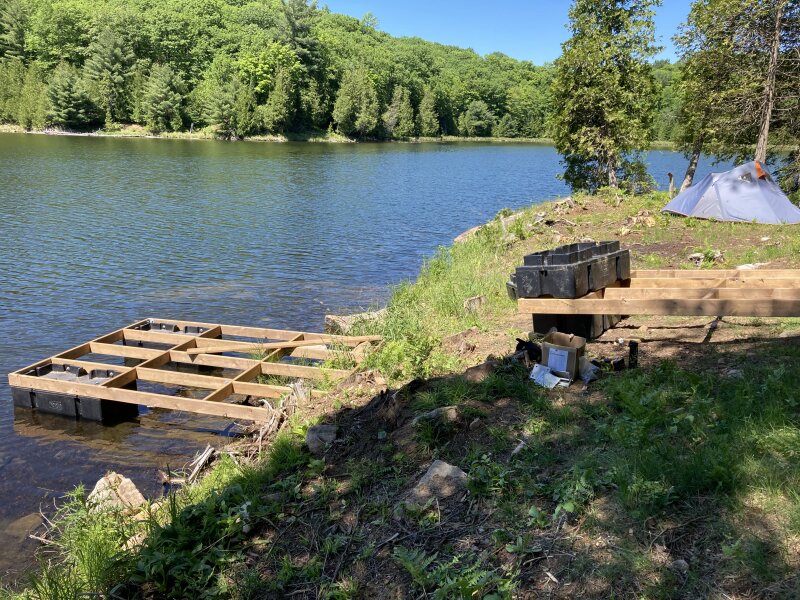 Assembling the ramp section of the dock on shore, preparing to push it out with the first section