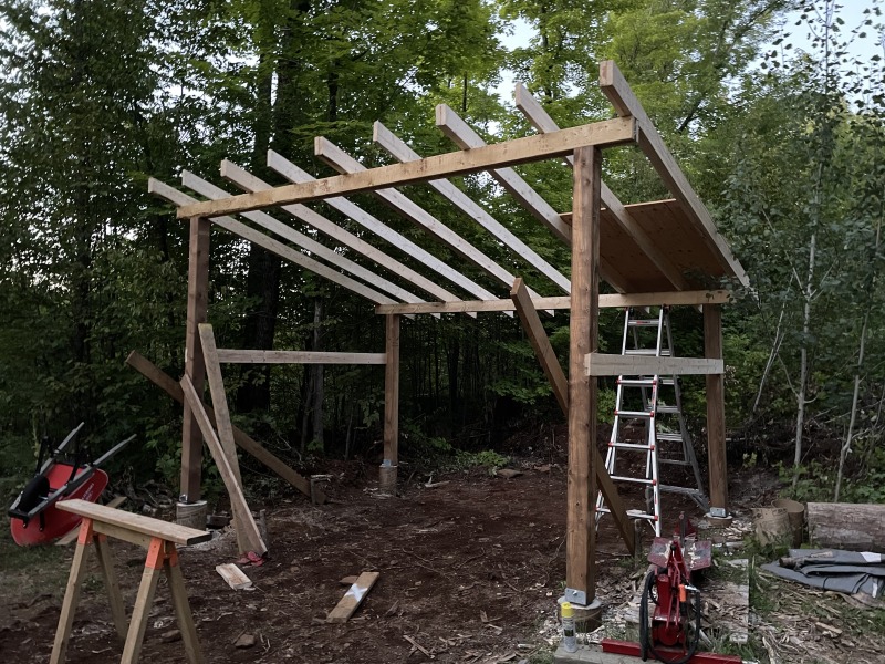 The first sheet of plywood going on the roof at dusk