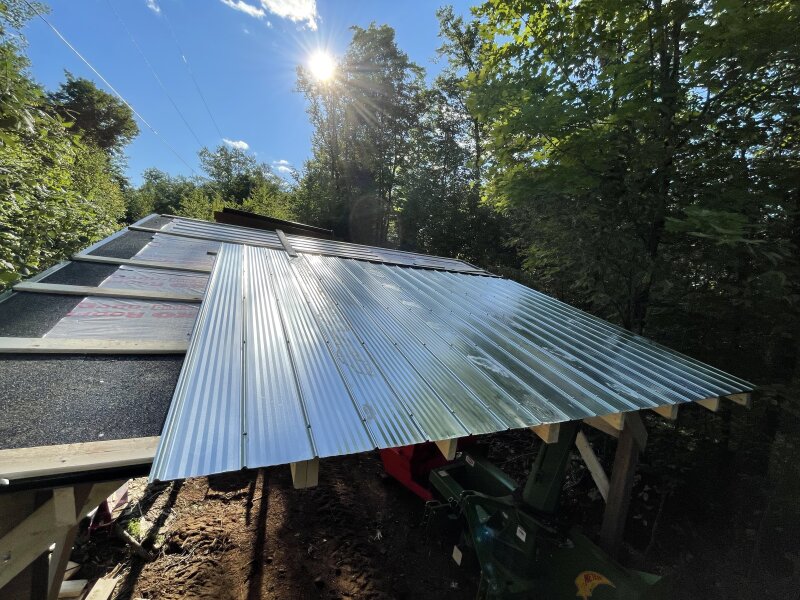 The first few sheets of metal going on the roof after underlayment