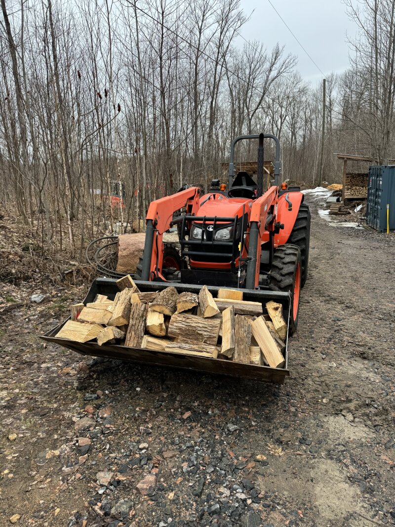 The tractor bucket loaded up with firewood