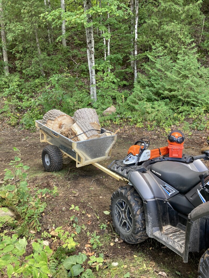The ATV arriving back at the lakefront with a trailer load of logs