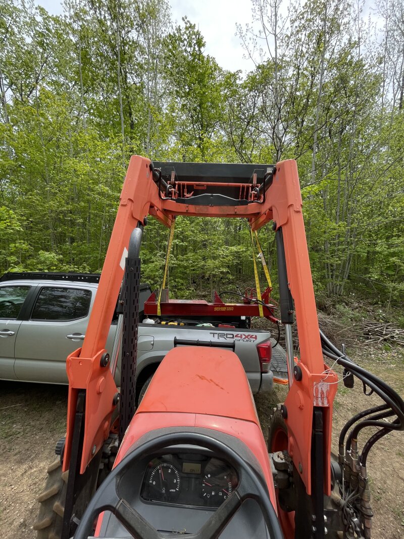 Unloading the splitter from the pickup bed with the tractor loader