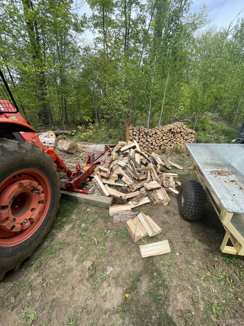 The splitfire behind the tractor, but not attached to the 3-point hitch. Instead, it sits behind the winch, hydraulic lines running behind and up to the hydraulic ports.