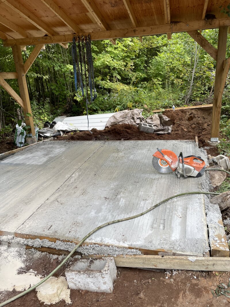 A concrete saw sitting on the concrete slab, relief cuts freshly cut