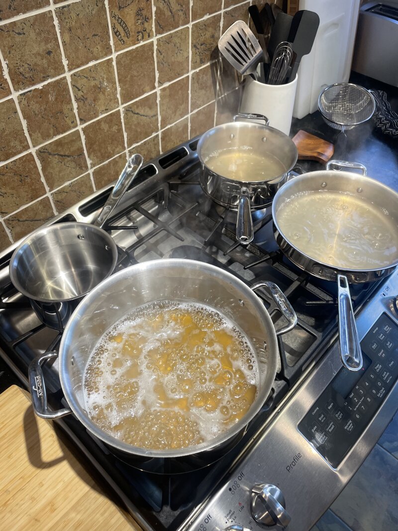 Four different pots and pans on my gas range at home, all at a rolling boil with light-coloured sap in them